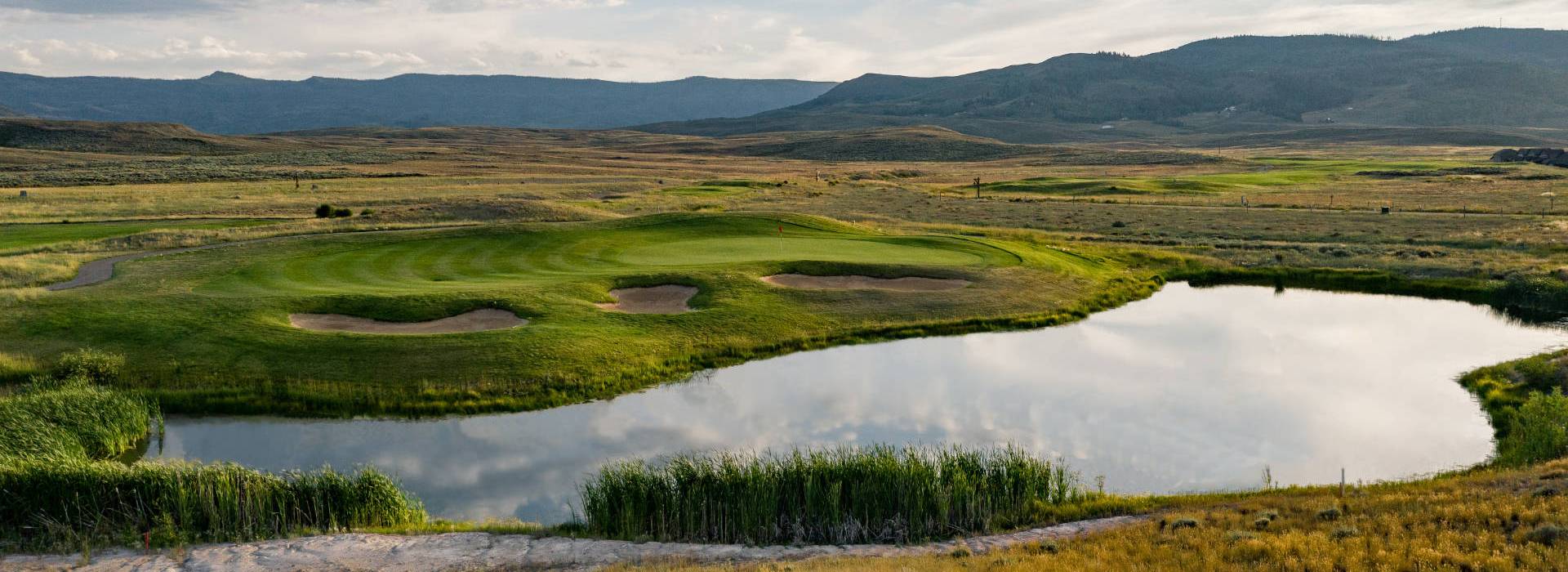 View of golf course with pond